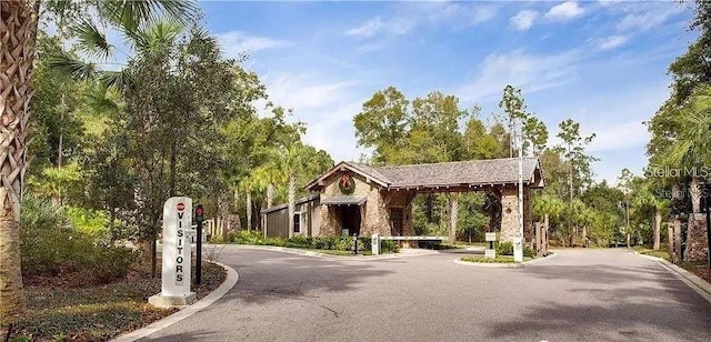 2807 Alder Berry Blvd, Ocoee, FL 34761 - view of asphalt road with curbs and a gated entry