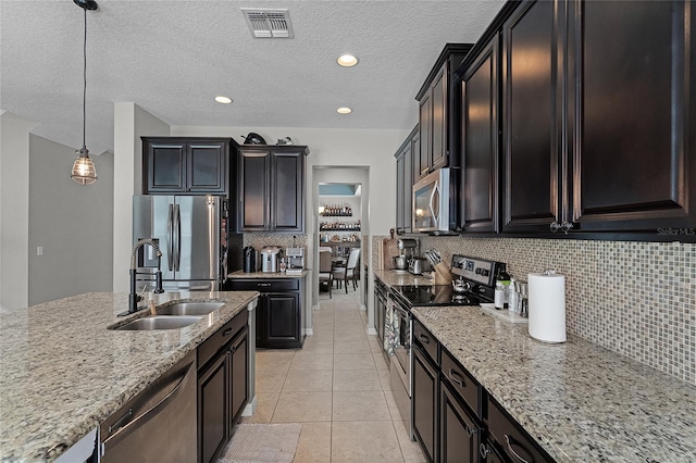 750 Maple Leaf Loop, Winter Springs, FL 32708 - kitchen featuring appliances with stainless steel finishes, a sink, light stone countertops, tasteful backsplash, and light tile patterned flooring