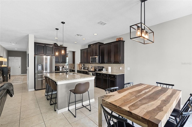 750 Maple Leaf Loop, Winter Springs, FL 32708 - kitchen featuring appliances with stainless steel finishes, a sink, tasteful backsplash, a kitchen bar, and an island with sink