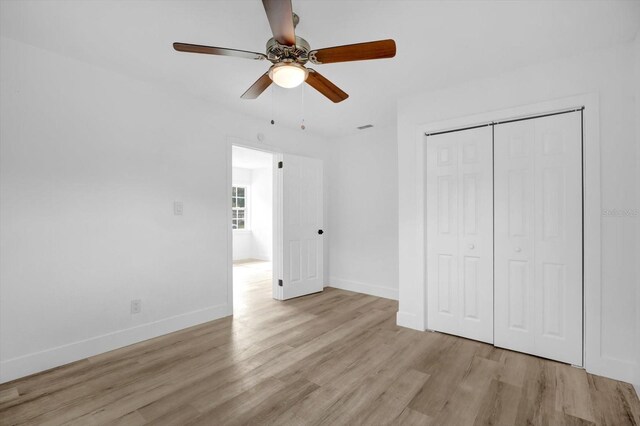 906 Kensington Dr, Orlando, FL 32808 - unfurnished bedroom with wood finished floors, baseboards, a closet, and a ceiling fan