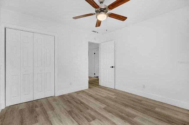 906 Kensington Dr, Orlando, FL 32808 - unfurnished bedroom with baseboards, wood finished floors, a closet, and a ceiling fan