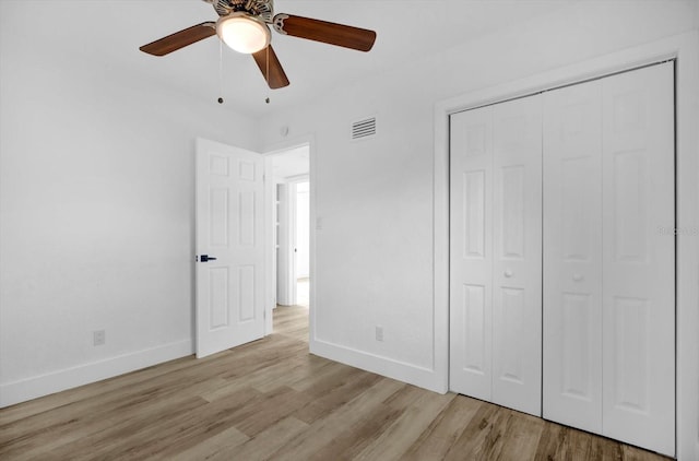906 Kensington Dr, Orlando, FL 32808 - unfurnished bedroom with baseboards, light wood-style floors, a closet, and a ceiling fan