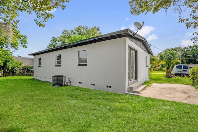 906 Kensington Dr, Orlando, FL 32808 - back of house with crawl space, a yard, central air condition unit, and stucco siding