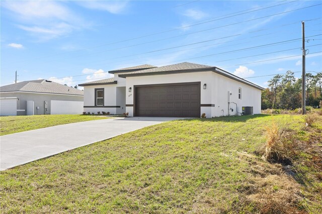 16730 SW 50th Cir, Ocala, FL 34473 - view of front of home with cooling unit, a garage, a front lawn, stucco siding, and driveway