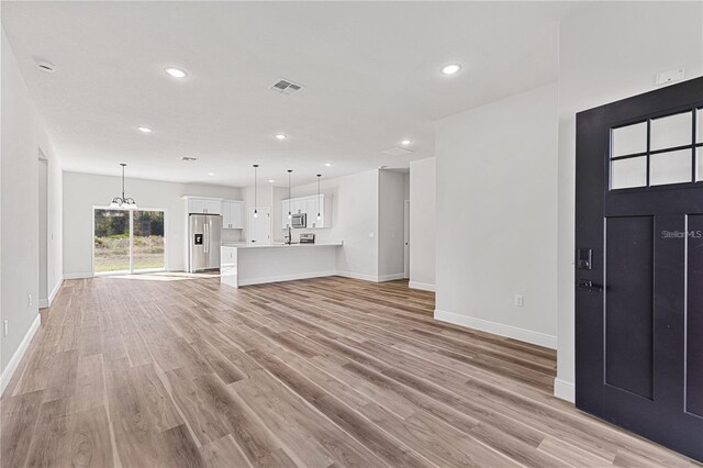 16730 SW 50th Cir, Ocala, FL 34473 - unfurnished living room with baseboards, recessed lighting, light wood finished floors, and a chandelier