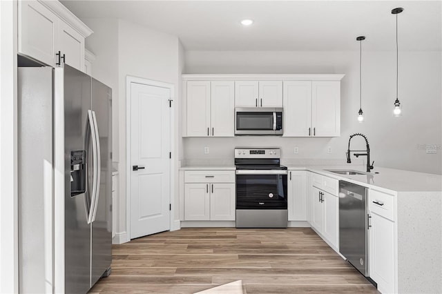 16730 SW 50th Cir, Ocala, FL 34473 - kitchen with appliances with stainless steel finishes, a sink, light countertops, light wood finished floors, and white cabinets