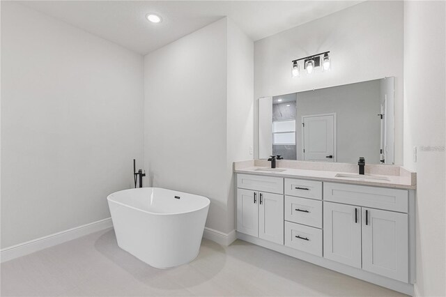 16730 SW 50th Cir, Ocala, FL 34473 - full bath with double vanity, a freestanding tub, baseboards, and recessed lighting
