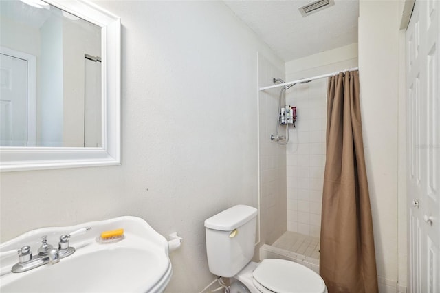 6663 NW 60th St, Ocala, FL 34482 - bathroom featuring toilet, a sink, a stall shower, and a textured ceiling