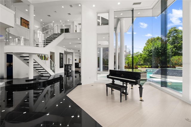9138 Great Heron Cir, Orlando, FL 32836 - living area with a wall of windows, a high ceiling, stairway, and recessed lighting