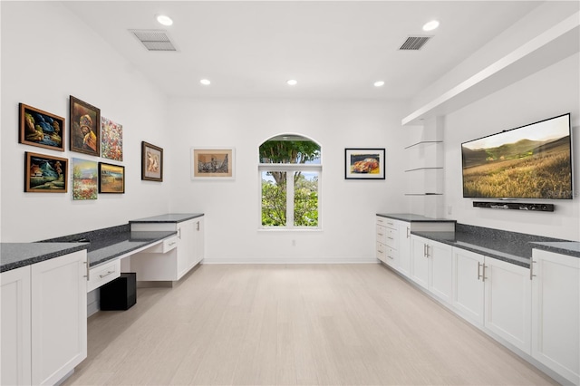 9138 Great Heron Cir, Orlando, FL 32836 - kitchen with built in study area, light wood-style floors, white cabinetry, recessed lighting, and dark stone countertops