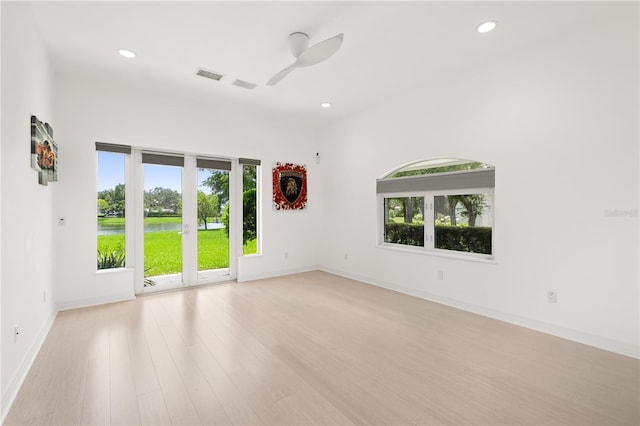 9138 Great Heron Cir, Orlando, FL 32836 - empty room with plenty of natural light, ceiling fan, recessed lighting, light wood-style flooring, and a water view