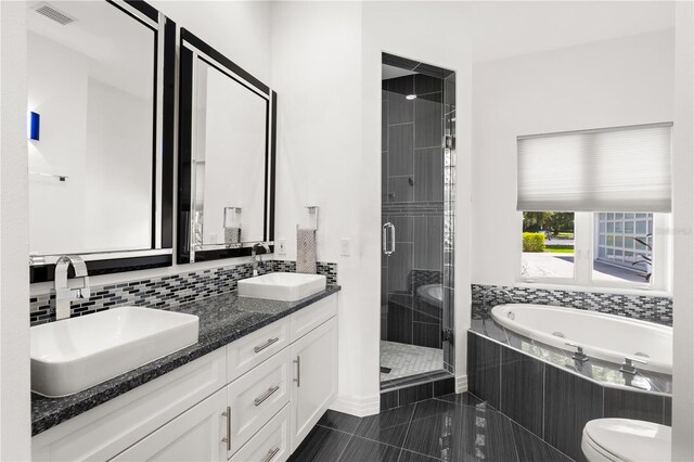 9138 Great Heron Cir, Orlando, FL 32836 - bathroom featuring a stall shower, double vanity, a bath, and decorative backsplash
