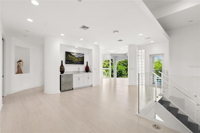 9138 Great Heron Cir, Orlando, FL 32836 - unfurnished living room featuring light wood-style flooring, recessed lighting, and a dry bar