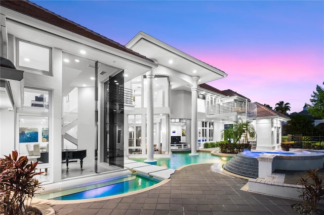 9138 Great Heron Cir, Orlando, FL 32836 - pool at dusk featuring a pool with connected hot tub and a patio