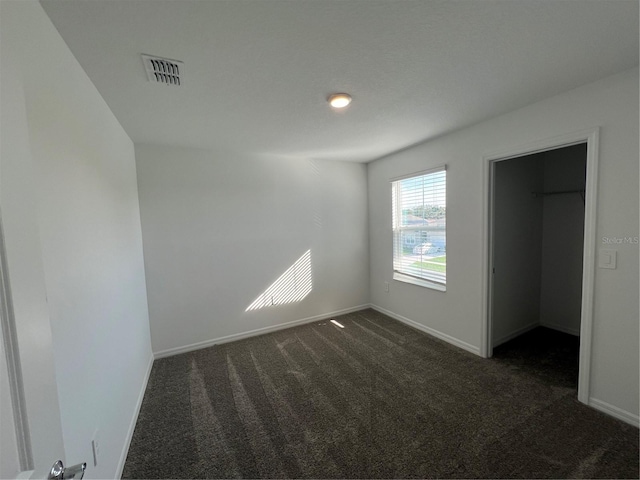 930 Cattleman St, Winter Haven, FL 33881 - unfurnished bedroom featuring dark colored carpet, baseboards, and a spacious closet