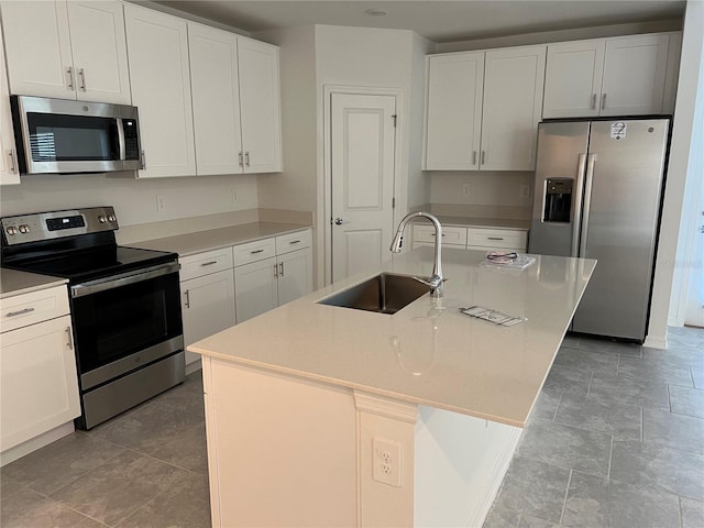 930 Cattleman St, Winter Haven, FL 33881 - kitchen with appliances with stainless steel finishes, a sink, white cabinetry, a kitchen island with sink, and light countertops
