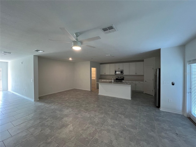 930 Cattleman St, Winter Haven, FL 33881 - unfurnished living room featuring ceiling fan, baseboards, a sink, and healthy amount of natural light