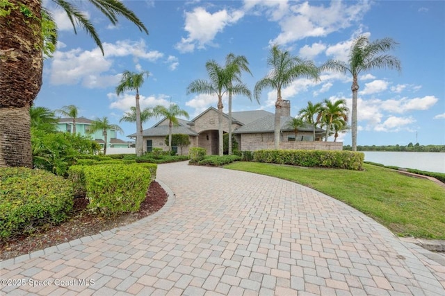 1175 Tuckaway Dr, Rockledge, FL 32955 - view of front of house with curved driveway, a water view, and a front lawn