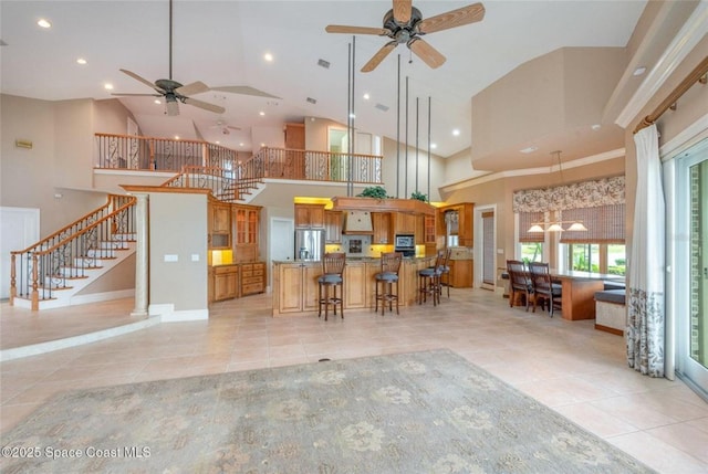 1175 Tuckaway Dr, Rockledge, FL 32955 - kitchen featuring stainless steel fridge, ceiling fan, light tile patterned floors, a kitchen breakfast bar, and brown cabinets