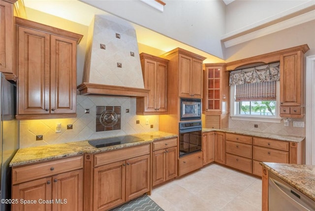 1175 Tuckaway Dr, Rockledge, FL 32955 - kitchen featuring black appliances, custom exhaust hood, light stone countertops, brown cabinetry, and decorative backsplash