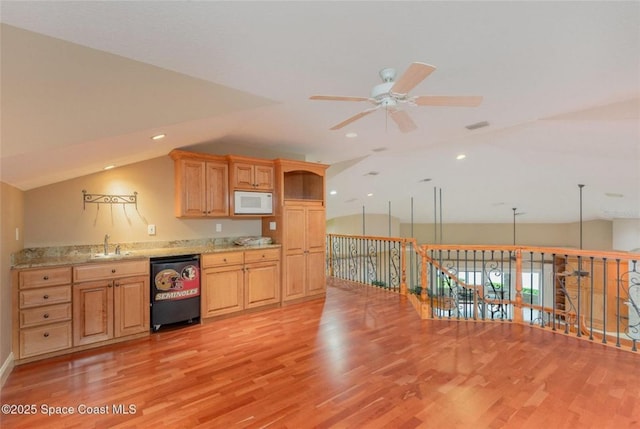 1175 Tuckaway Dr, Rockledge, FL 32955 - kitchen with dishwashing machine, white microwave, a sink, a ceiling fan, and vaulted ceiling