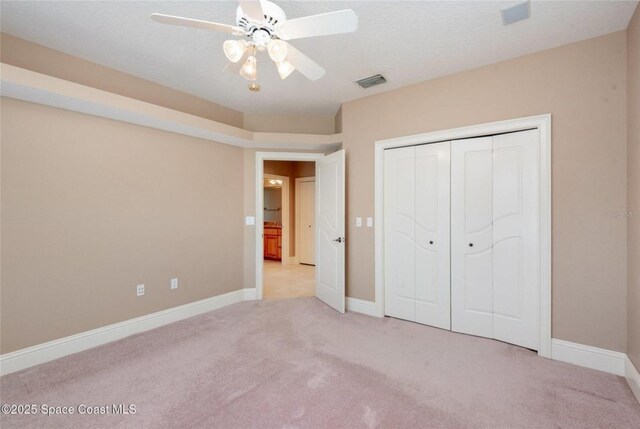 1175 Tuckaway Dr, Rockledge, FL 32955 - unfurnished bedroom featuring light carpet, a closet, baseboards, and a ceiling fan