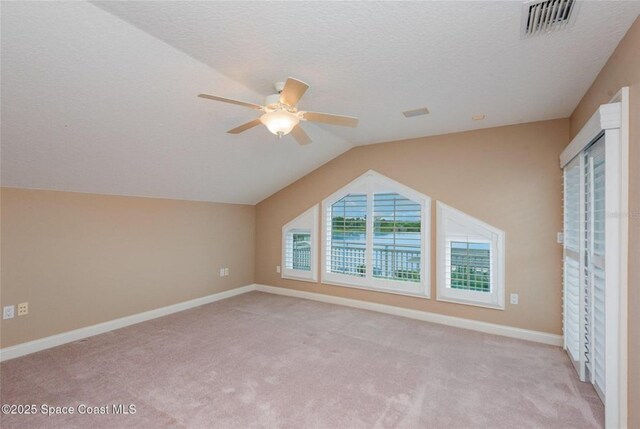 1175 Tuckaway Dr, Rockledge, FL 32955 - bonus room featuring ceiling fan, light carpet, lofted ceiling, baseboards, and a textured ceiling