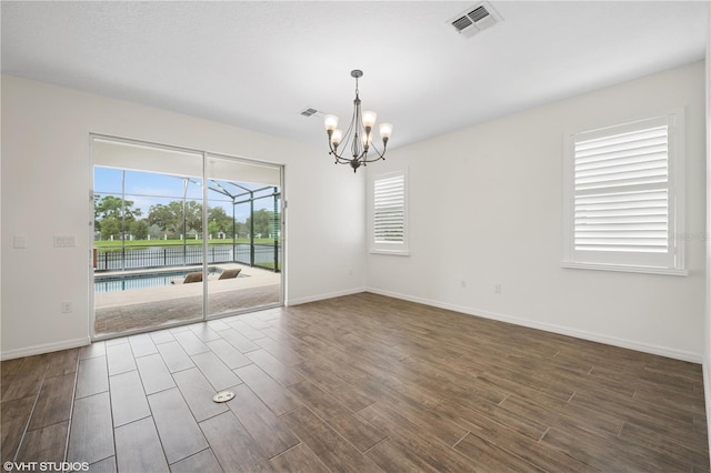 2659 Magpie Way, Sanford, FL 32773 - empty room featuring a chandelier, dark wood-style flooring, baseboards, and a sunroom
