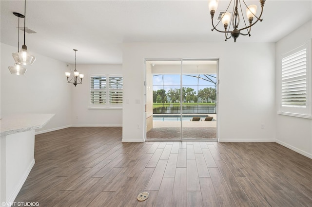 2659 Magpie Way, Sanford, FL 32773 - unfurnished dining area with a chandelier, wood finished floors, and baseboards