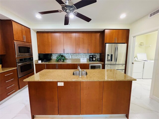 1925 S Atlantic Ave Unit 411, Daytona Beach, FL 32118 - kitchen with stainless steel appliances, washer and clothes dryer, light marble finish flooring, a sink, and tasteful backsplash