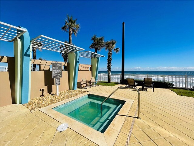 1925 S Atlantic Ave Unit 411, Daytona Beach, FL 32118 - view of swimming pool with a hot tub, a water view, and a patio area