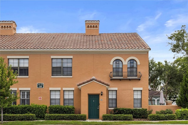 730 Siena Palm Dr Unit 201, Celebration, FL 34747 - view of front of home featuring a tiled roof, stucco siding, and a chimney