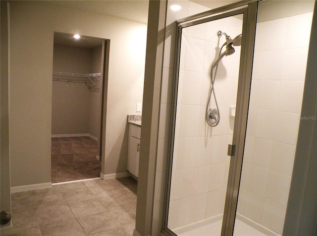 17305 Cagan Crossings Blvd, Clermont, FL 34714 - bathroom with a stall shower, a walk in closet, vanity, and baseboards