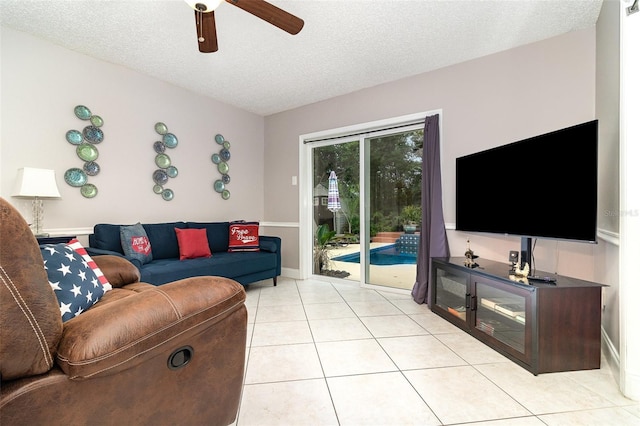 7058 Archwood Dr, Orlando, FL 32819 - living room featuring ceiling fan, a textured ceiling, light tile patterned floors, and baseboards