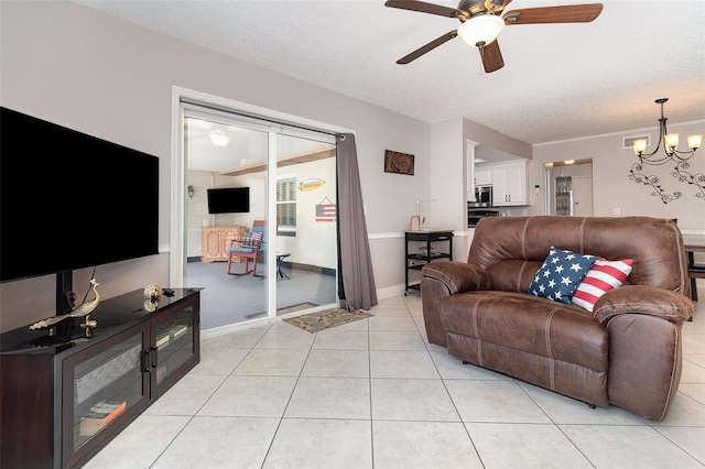 7058 Archwood Dr, Orlando, FL 32819 - living area featuring ceiling fan, a chandelier, light tile patterned floors, and a textured ceiling