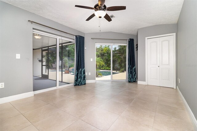 7058 Archwood Dr, Orlando, FL 32819 - unfurnished room featuring ceiling fan, a textured ceiling, lofted ceiling, baseboards, and light tile patterned floors