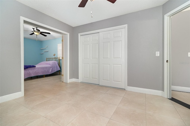 7058 Archwood Dr, Orlando, FL 32819 - bedroom featuring light tile patterned flooring, a closet, a ceiling fan, and baseboards