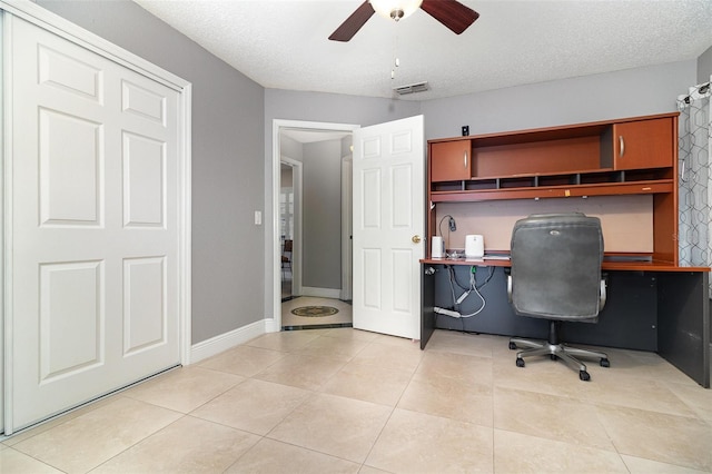 7058 Archwood Dr, Orlando, FL 32819 - home office featuring built in desk, ceiling fan, light tile patterned flooring, baseboards, and a textured ceiling
