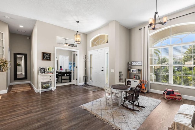 610 Strihal Loop, Oakland, FL 34787 - entrance foyer featuring baseboards, a chandelier, dark wood-type flooring, and a textured ceiling
