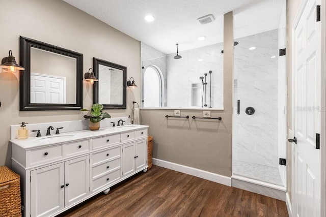 610 Strihal Loop, Oakland, FL 34787 - full bath with double vanity, a marble finish shower, wood finished floors, baseboards, and recessed lighting