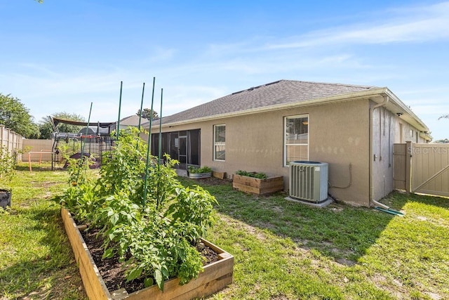 610 Strihal Loop, Oakland, FL 34787 - back of property featuring a vegetable garden, central AC, and stucco siding