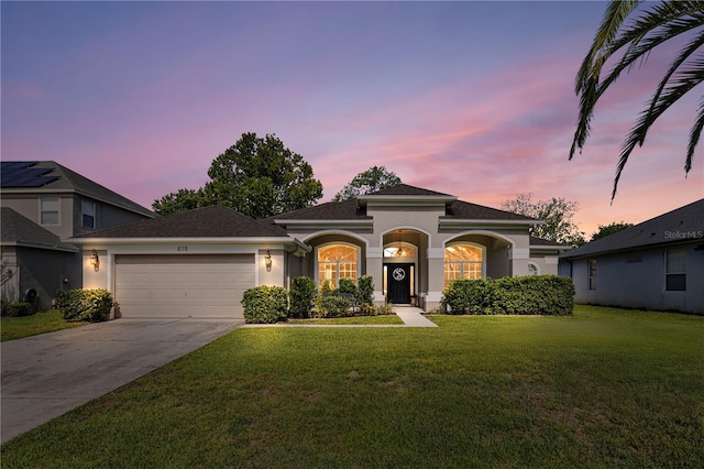 610 Strihal Loop, Oakland, FL 34787 - mediterranean / spanish home featuring stucco siding, an attached garage, concrete driveway, a lawn, and a shingled roof