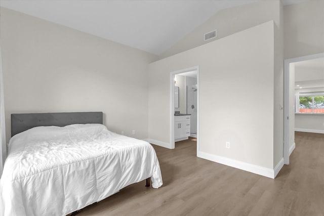 3622 Huntwicke Blvd, Davenport, FL 33837 - bedroom featuring wood finished floors, vaulted ceiling, baseboards, and ensuite bathroom