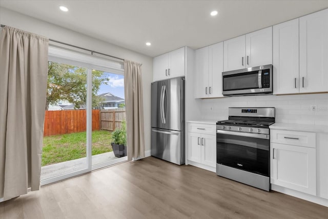 3622 Huntwicke Blvd, Davenport, FL 33837 - kitchen featuring stainless steel appliances, tasteful backsplash, light wood finished floors, white cabinets, and recessed lighting