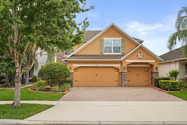 1613 Water Elm Ct, Orlando, FL 32825 - view of front of house featuring stone siding, stucco siding, an attached garage, and decorative driveway