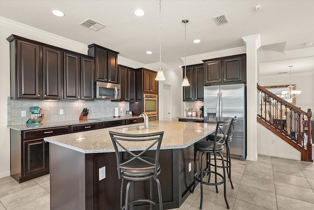 1613 Water Elm Ct, Orlando, FL 32825 - kitchen featuring stainless steel appliances, an island with sink, light stone countertops, a sink, and tasteful backsplash