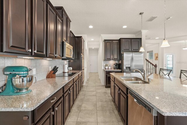 1613 Water Elm Ct, Orlando, FL 32825 - kitchen featuring a sink, appliances with stainless steel finishes, dark brown cabinetry, backsplash, and a large island