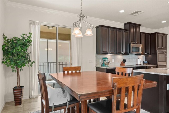 1613 Water Elm Ct, Orlando, FL 32825 - dining area featuring a chandelier, crown molding, baseboards, recessed lighting, and light tile patterned floors
