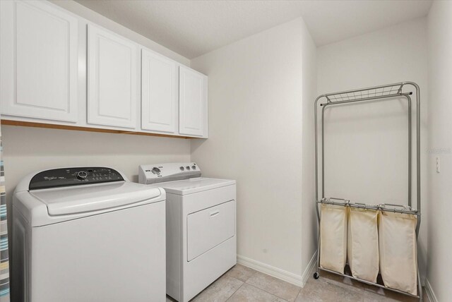 1613 Water Elm Ct, Orlando, FL 32825 - washroom featuring washing machine and dryer, baseboards, cabinet space, and light tile patterned flooring