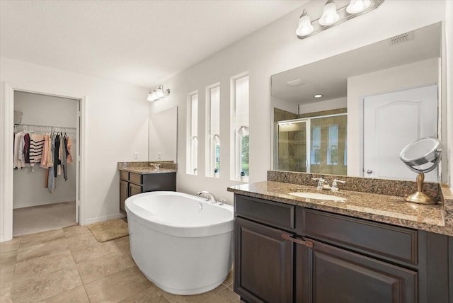 1613 Water Elm Ct, Orlando, FL 32825 - full bath with a shower stall, two vanities, a soaking tub, a spacious closet, and tile patterned floors